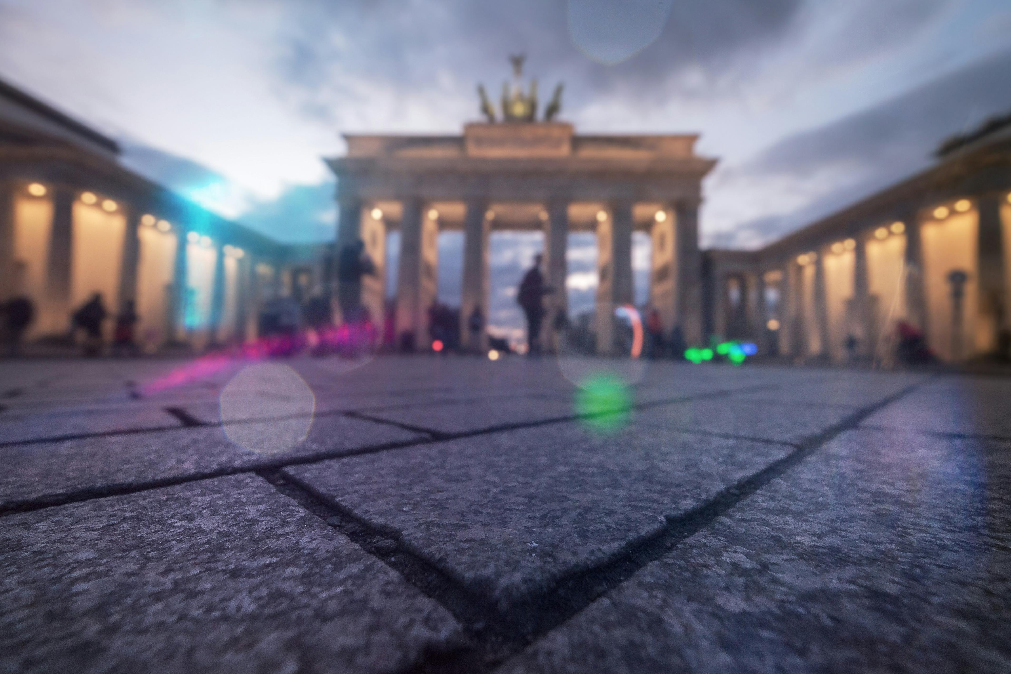 Brandenburg Gate in Berlin with German flag colors illuminated at dusk