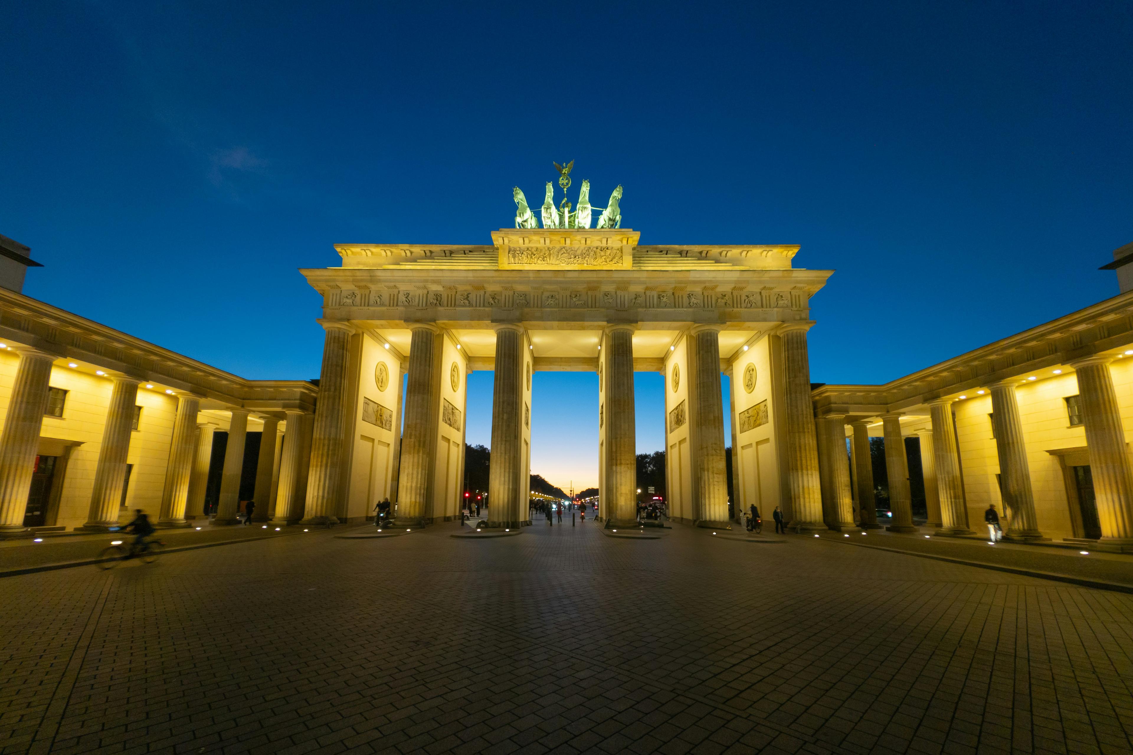Brandenburg Gate in Berlin with German flag colors illuminated at dusk